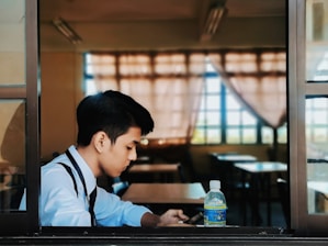 man in white and black shirt sitting at the table