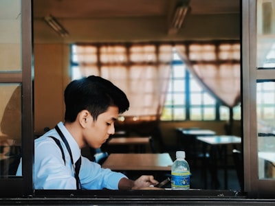 man in white and black shirt sitting at the table