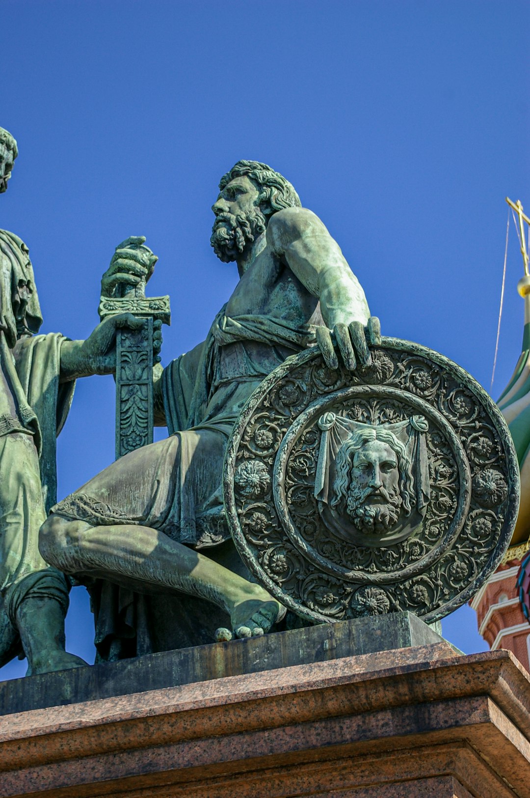 man holding round gold coin statue