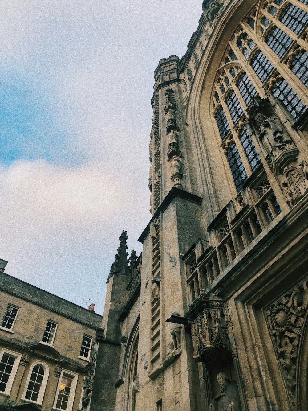 low angle photography of brown concrete building under white clouds during daytime