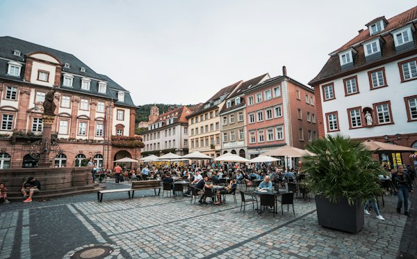 People sitting on chair near building during daytime — Heidelberg, Germany