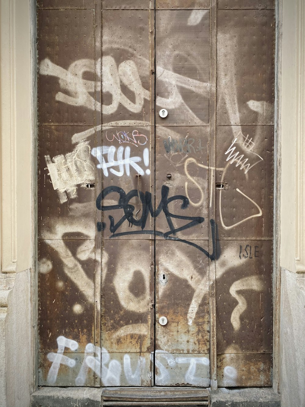 brown wooden door with graffiti