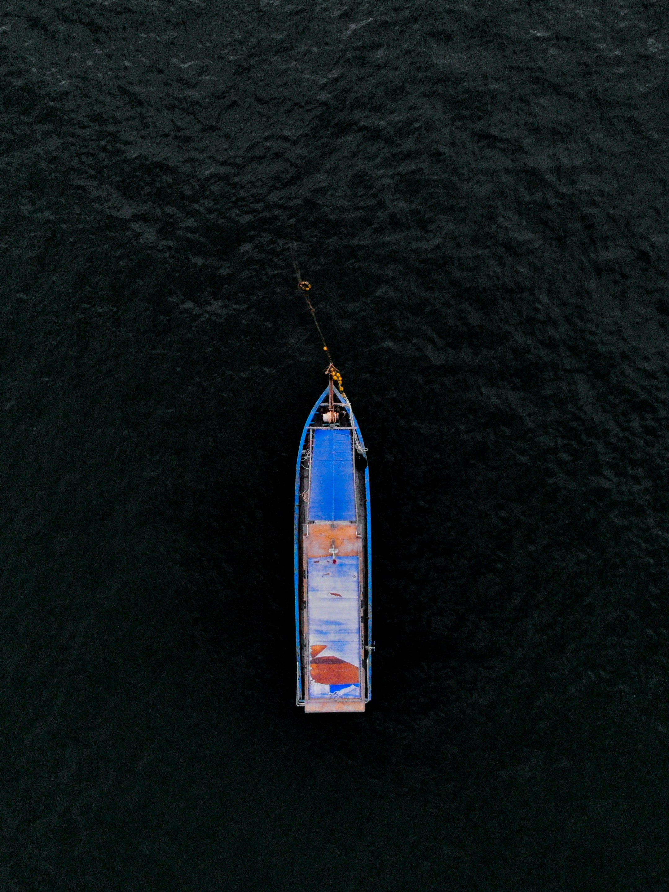 aerial view of white and blue boat on body of water during daytime