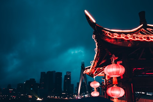Traditional Chinese architecture framed by blooming red lanterns in Macau.