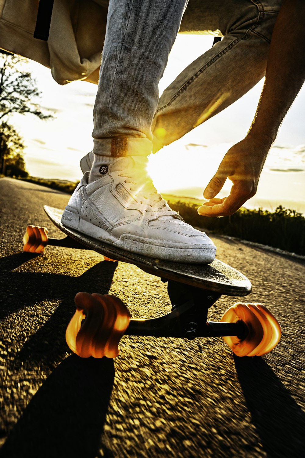 person in white pants and white shoes riding skateboard during daytime