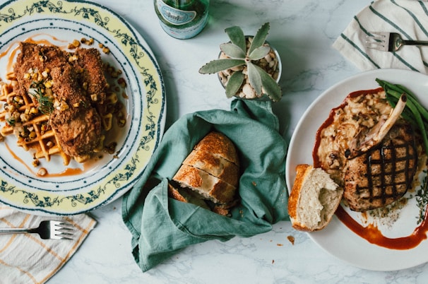 A cozy table setting with a plate of chicken and waffles alongside a glass of fresh lemonade