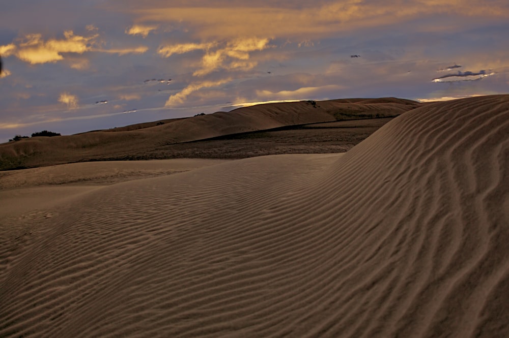brown sand under cloudy sky during daytime