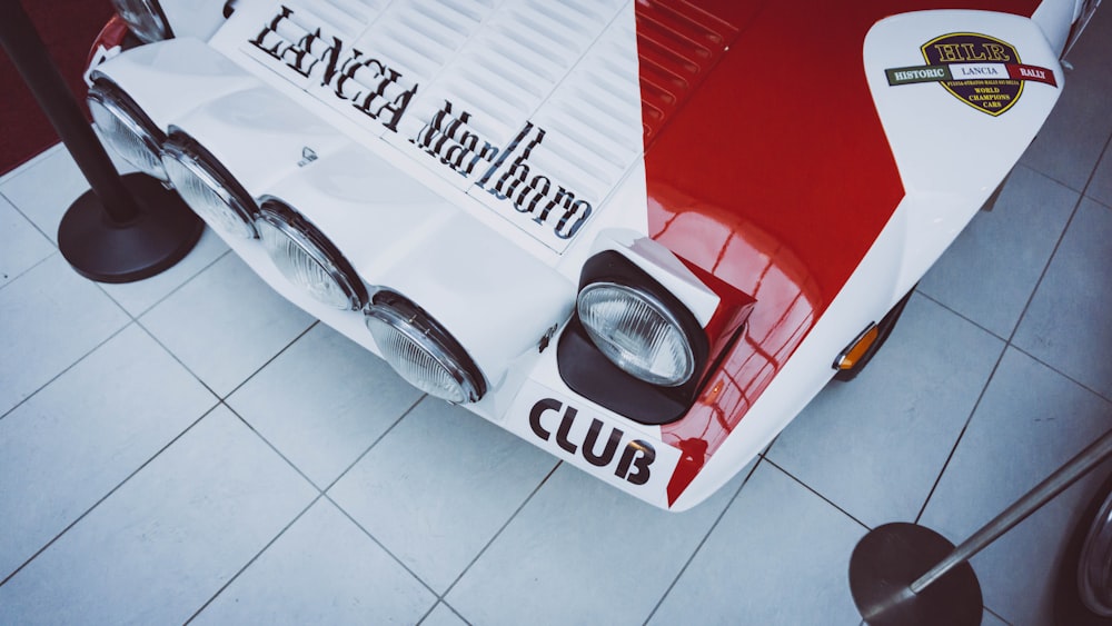 흰색 바닥 타일에 흰색과 빨간색 자동차