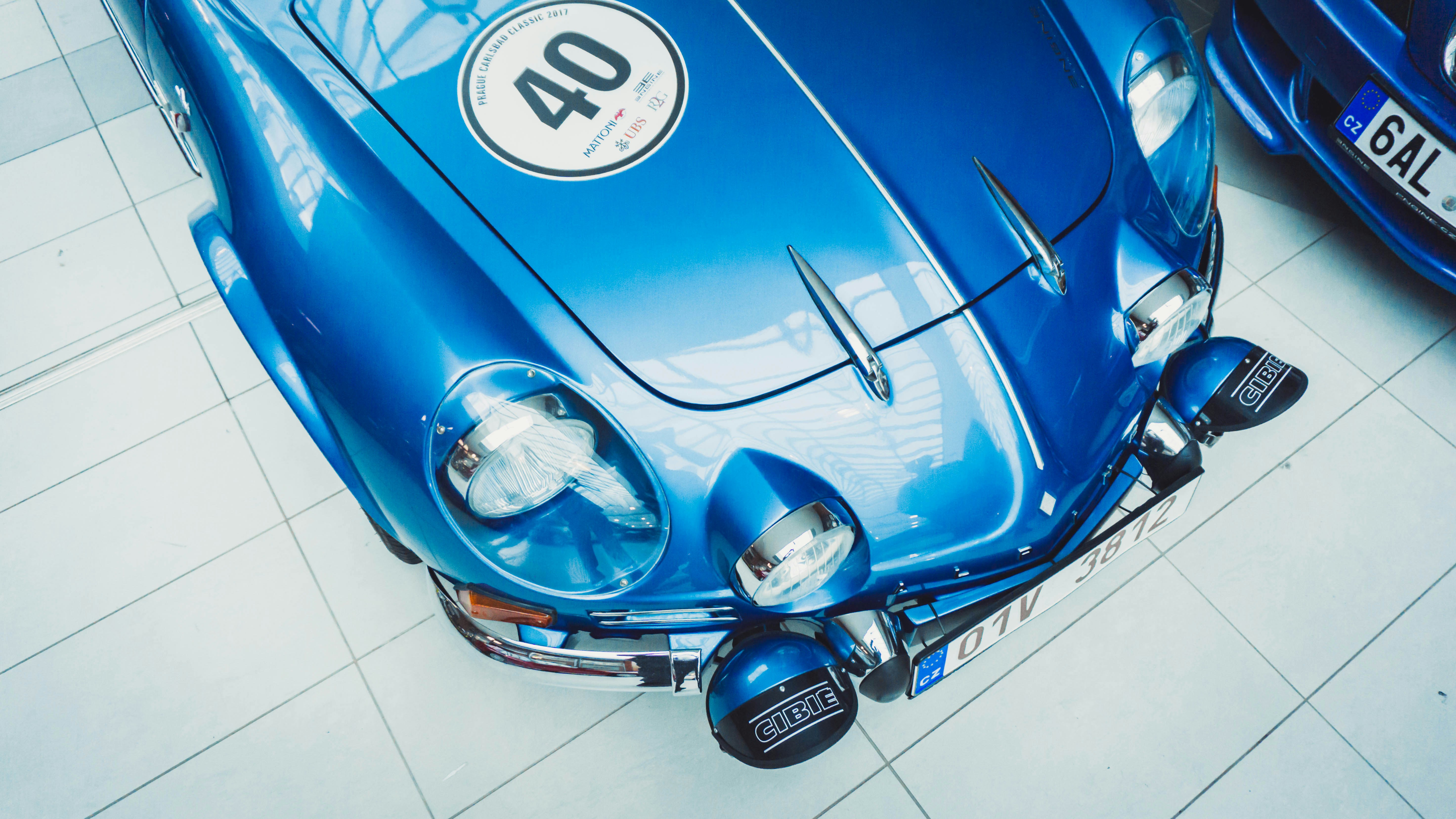 blue volkswagen beetle parked on white tiled floor
