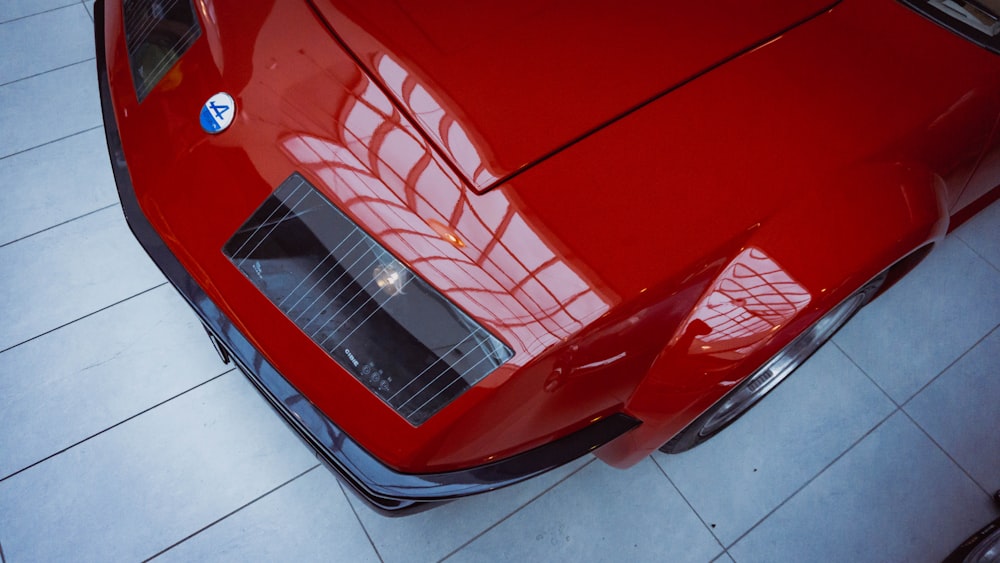 voiture rouge sur carreaux de céramique blancs