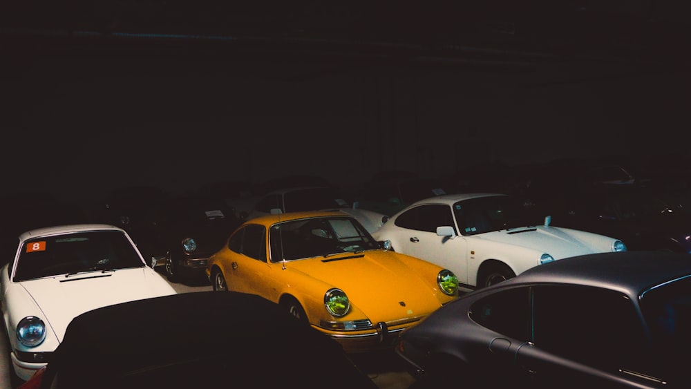 yellow and white coupe parked beside white car