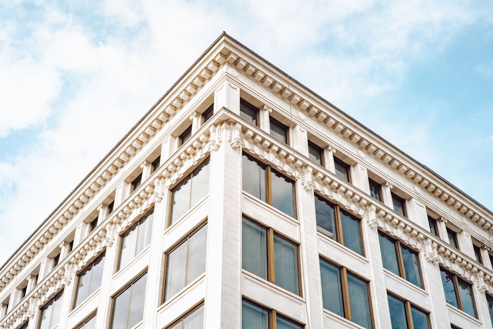 white concrete building under white clouds during daytime