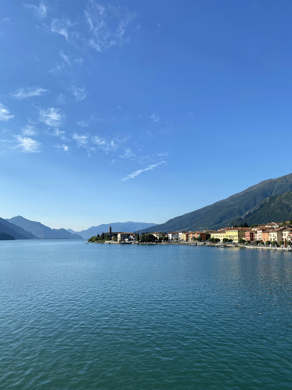 body of water near mountain under blue sky during daytime