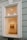 A large window on a building wall reveals the interior of an art gallery, featuring a brightly lit room with a painting of several people walking. The walls are painted a soft cream color, and some lighting fixtures are visible on the ceiling, casting light onto the artwork.
