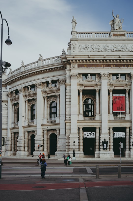 people walking near white concrete building during daytime in Burgtheater Austria