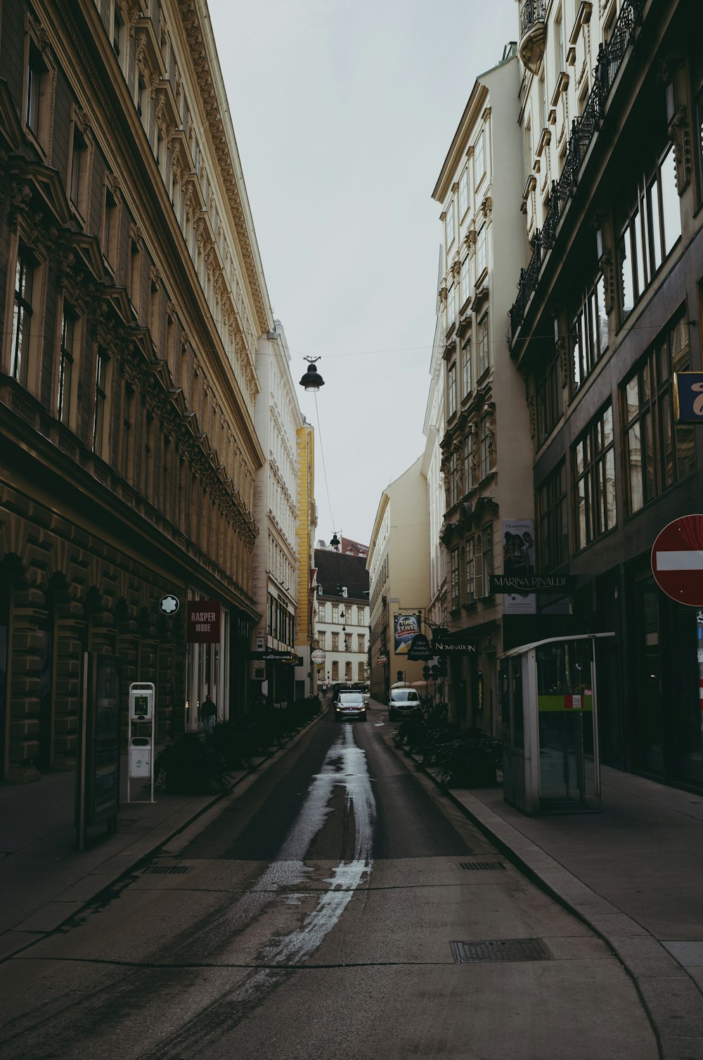 people walking on sidewalk between buildings during daytime