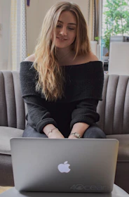woman in black sweater sitting on gray couch