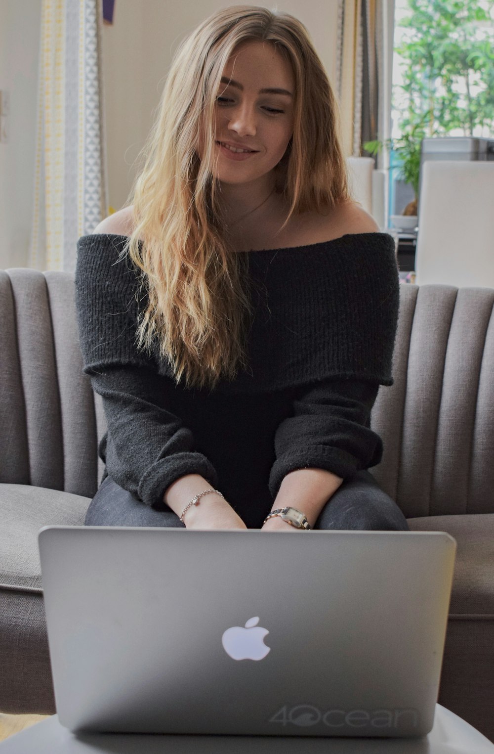 woman in black sweater sitting on gray couch