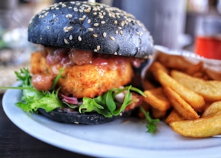 burger with lettuce and tomato on white ceramic plate