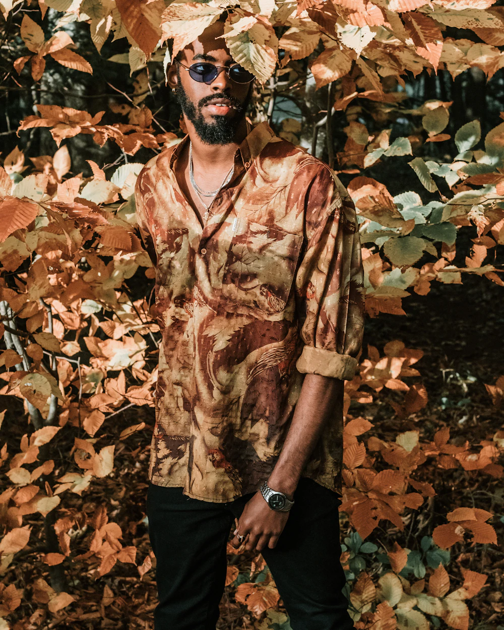 A man in a rich brown shirt among autumn leaves