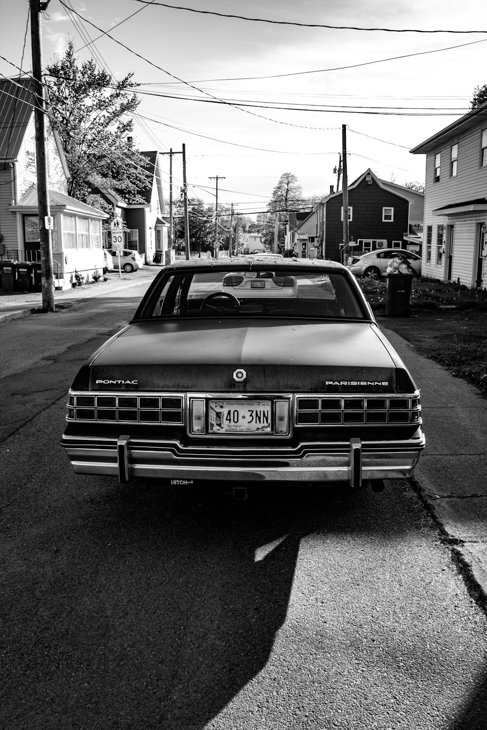 grayscale photo of bmw car parked on sidewalk