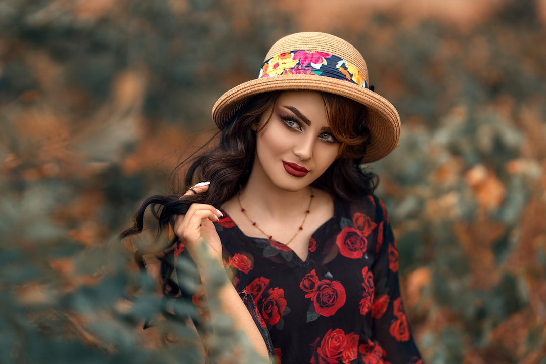 woman in red and black floral dress wearing brown hat