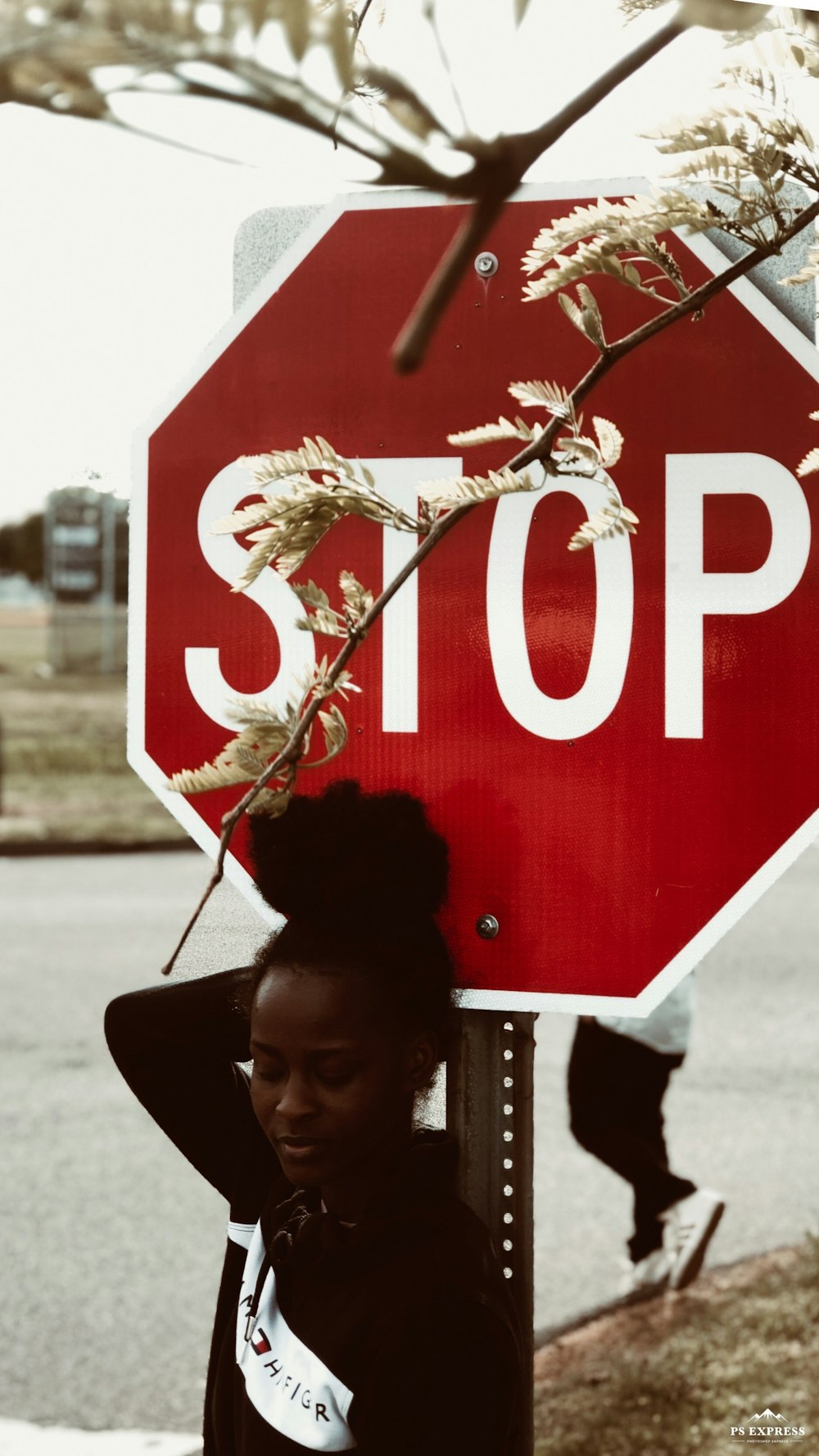 woman in black jacket holding stop sign