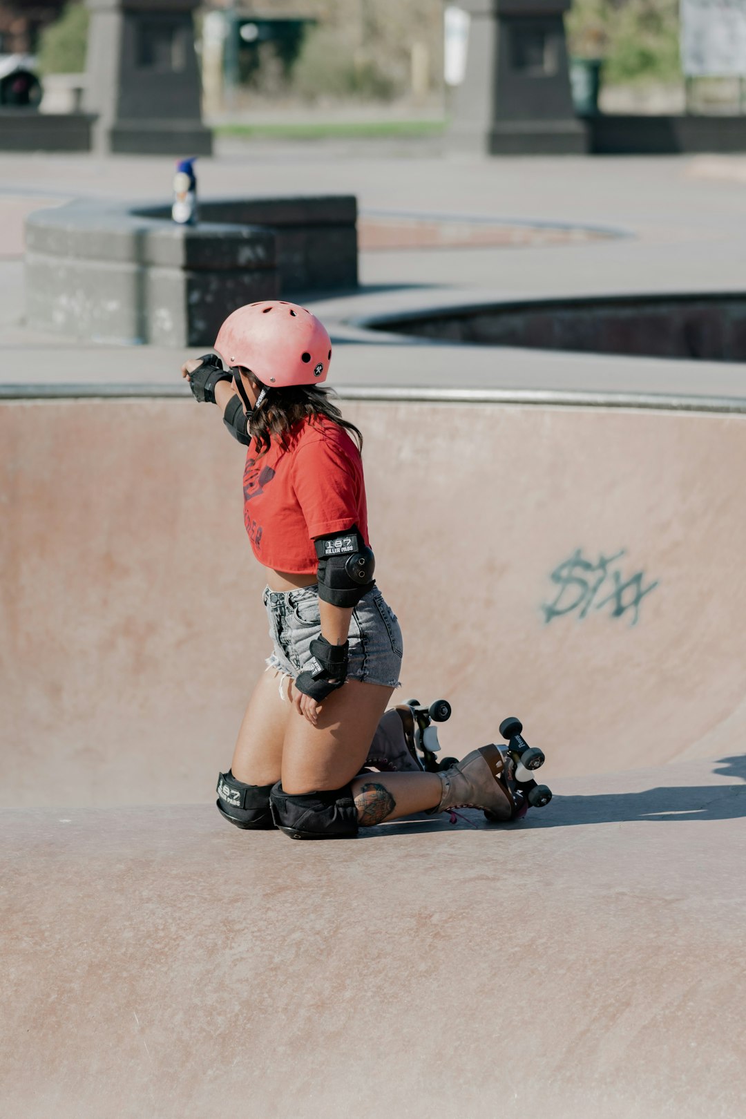 woman in red jacket and black shorts wearing red helmet