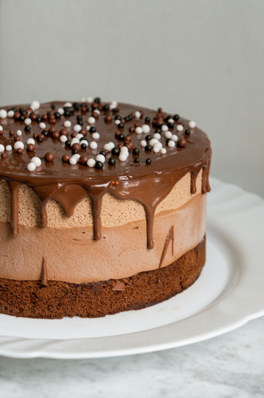 chocolate cake with white icing on white ceramic plate