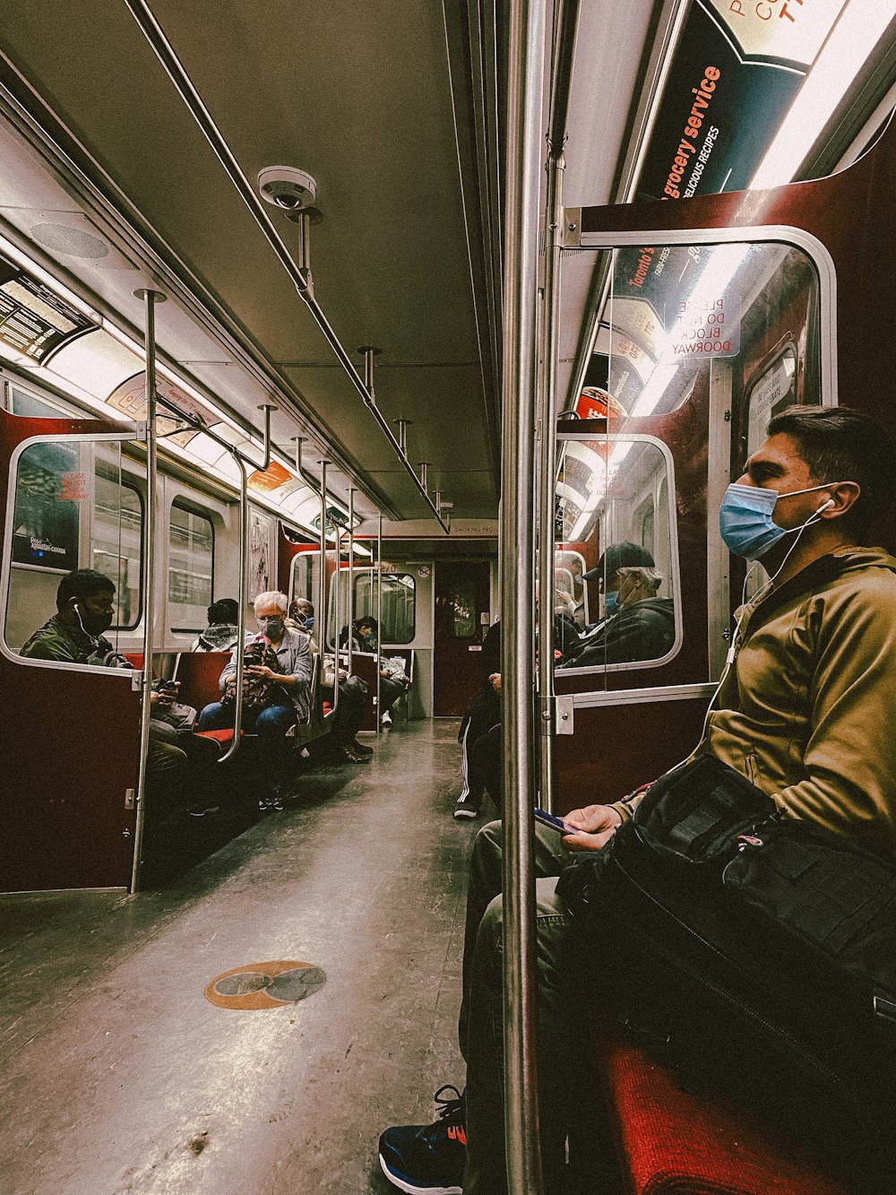 man in brown jacket sitting on train seat