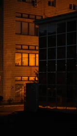Evening shot of a completed building illuminated with warm orange lighting.