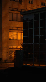 Evening shot of a completed building illuminated with warm orange lighting.