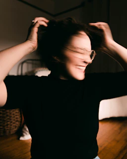 Therapist demonstrating movement resetting exercises with a smiling client.