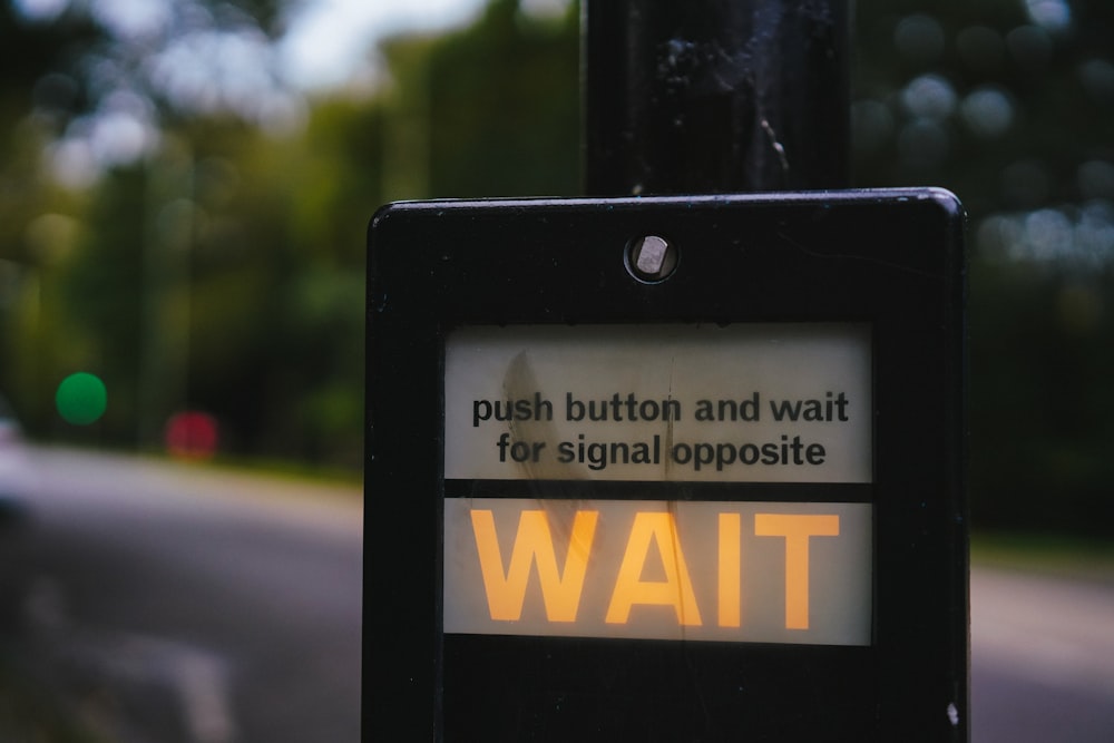 a sign that says push button and wait for signal opposite