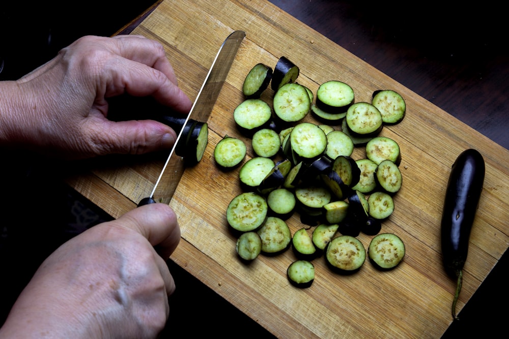 Persona sosteniendo cuchillo de cocina plateado y negro