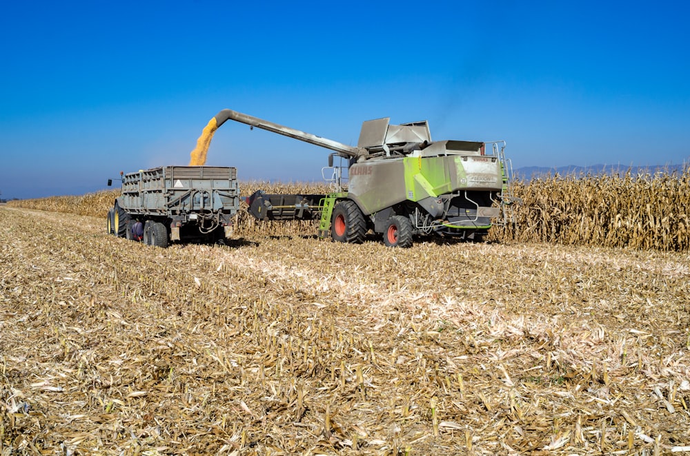 equipamento pesado verde e preto no campo de grama marrom durante o dia