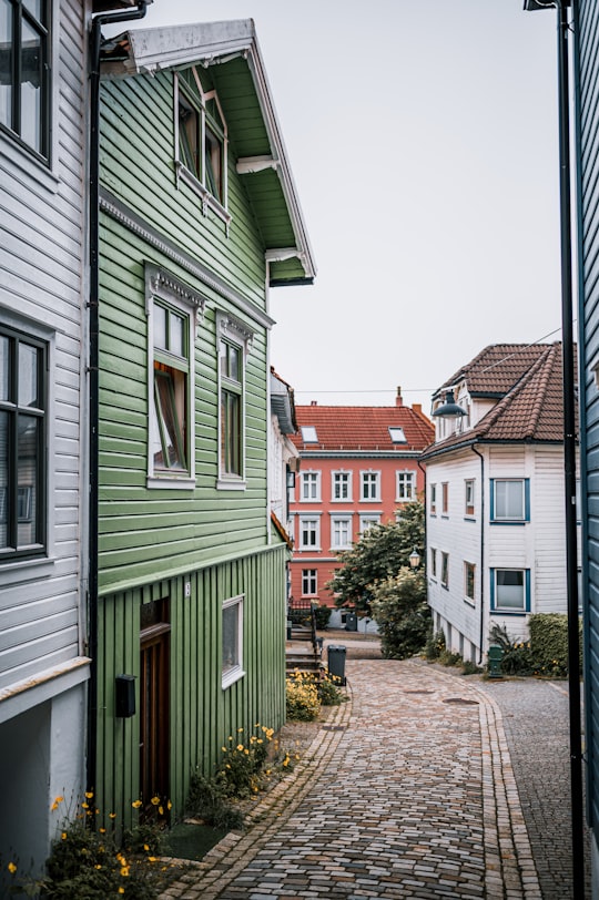 white and brown concrete house under white sky during daytime in Bergen Norway