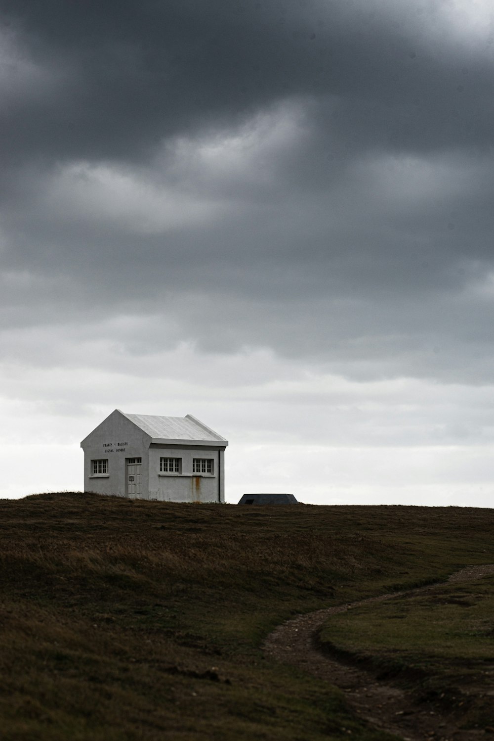 white wooden house on green grass field under white clouds