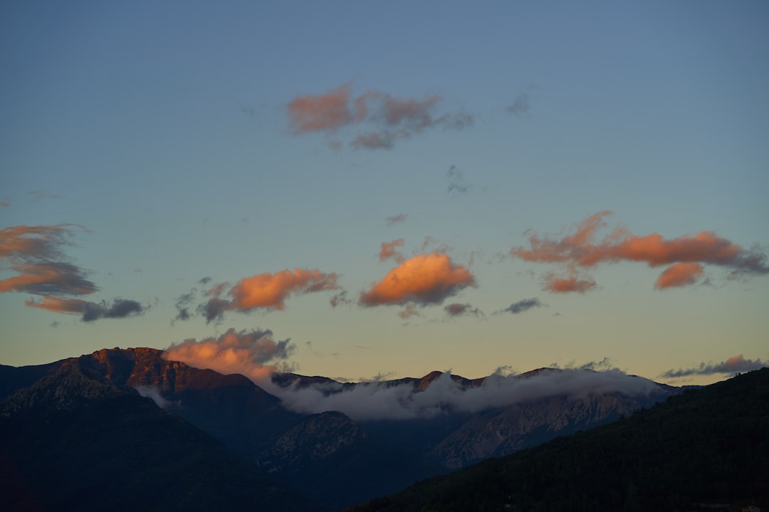 silhouette of mountains under cloudy sky during sunset