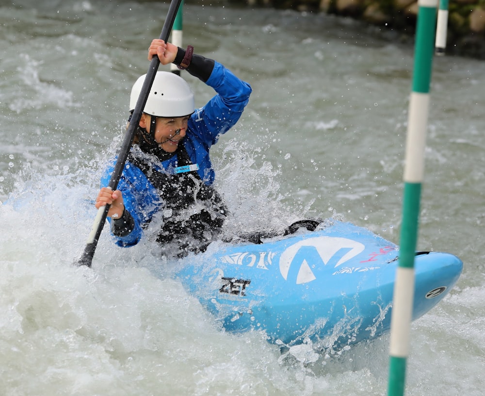 man in blue jacket riding on green and white surfboard