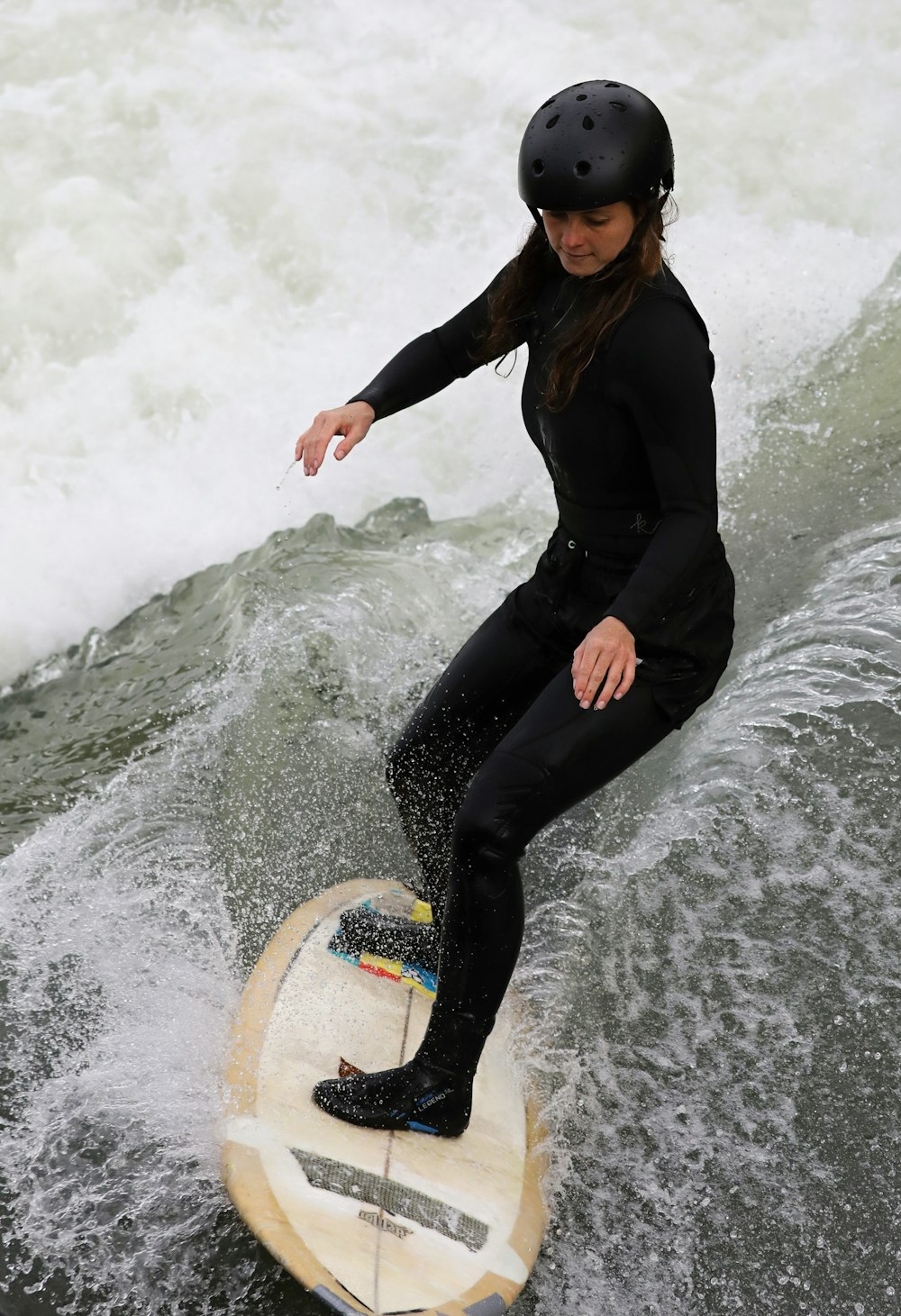 woman in black long sleeve shirt and black pants surfing on water during daytime