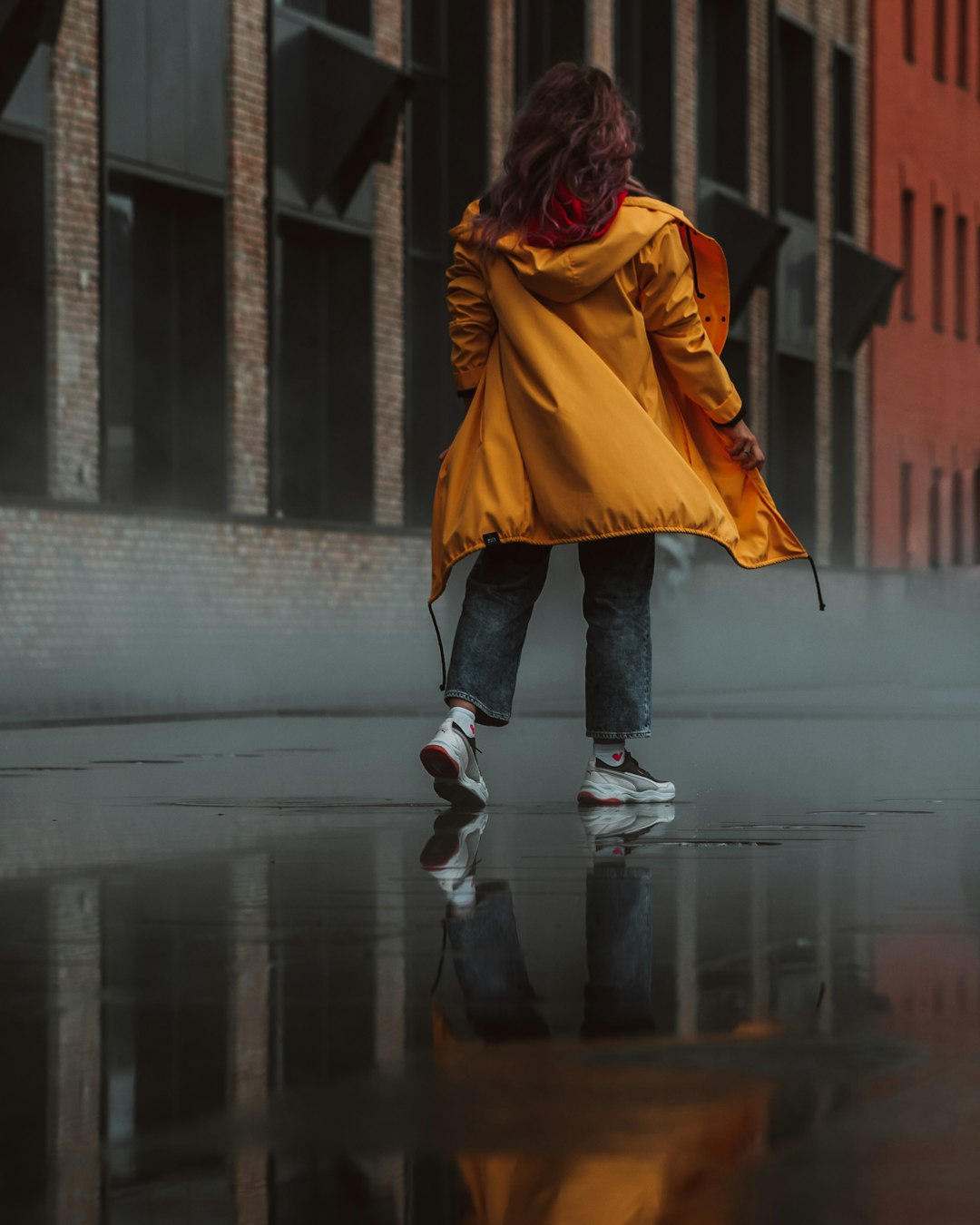 woman in yellow coat walking on street during daytime