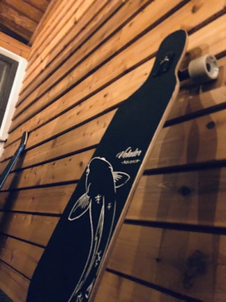 A classic cruiser board leaning on a wooden fence by the beach.
