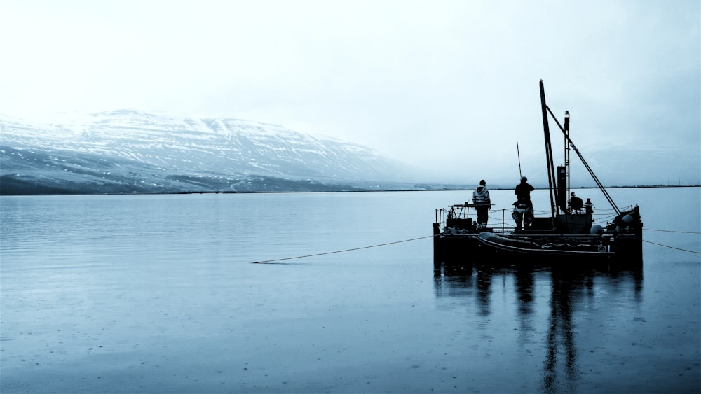 man in black boat on body of water during daytime