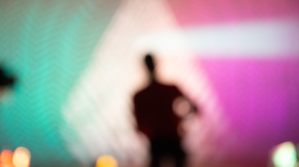 un'immagine sfocata di una persona in piedi di fronte a un muro