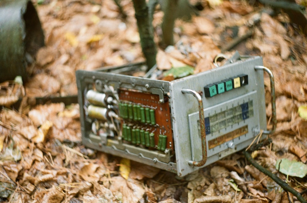 an old radio sitting on the ground in the woods