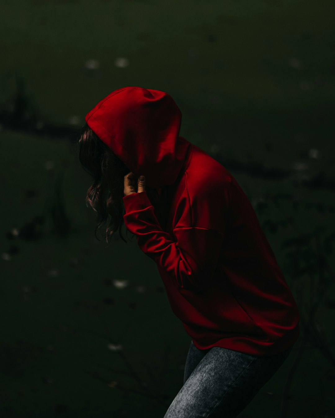 woman in red hoodie and blue denim jeans
