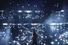 silhouette of person standing on stage with lights