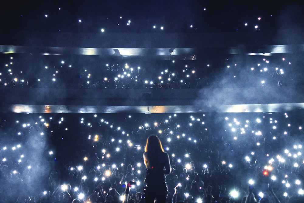 silhouette of person standing on stage with lights