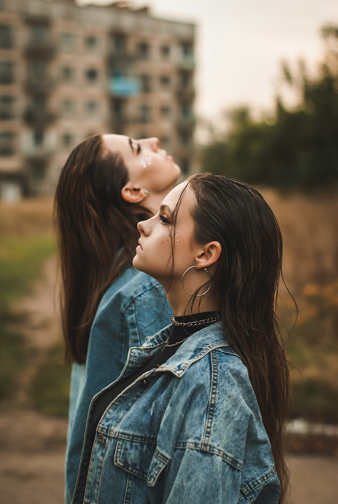 woman in blue denim jacket kissing womans cheek